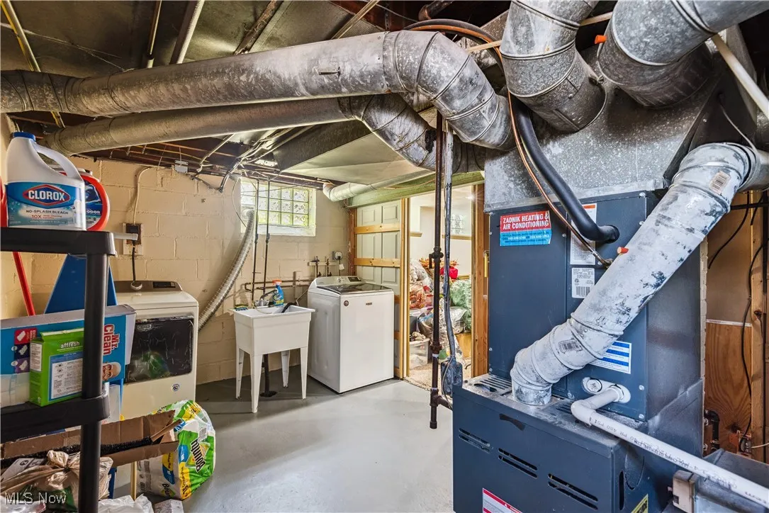 Basement featuring washer and dryer and heating unit