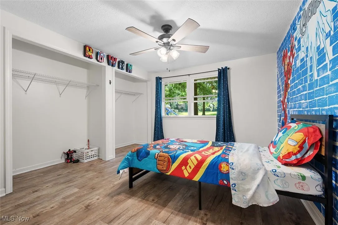 Bedroom featuring a textured ceiling, wood finished floors, and ceiling fan