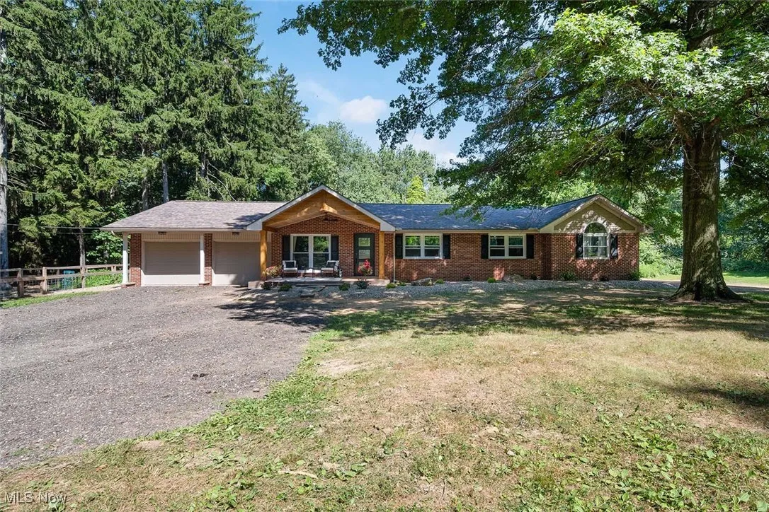 Ranch-style house featuring driveway, an attached garage, and brick siding