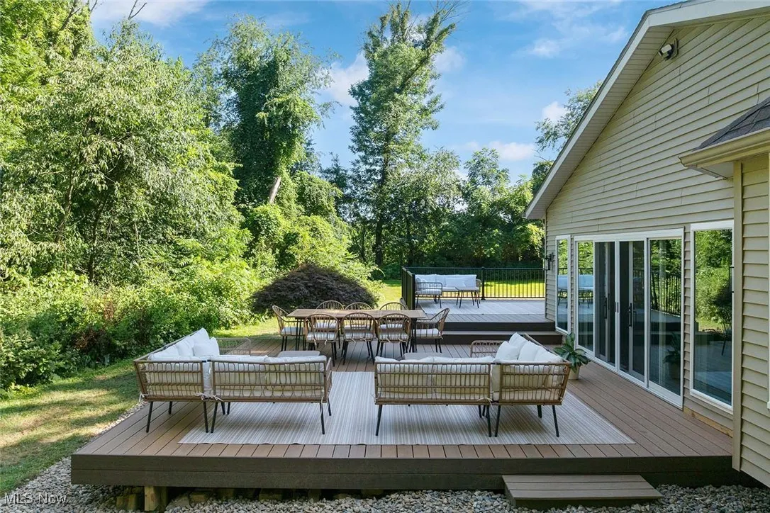 Wooden terrace with an outdoor living space and view of scattered trees