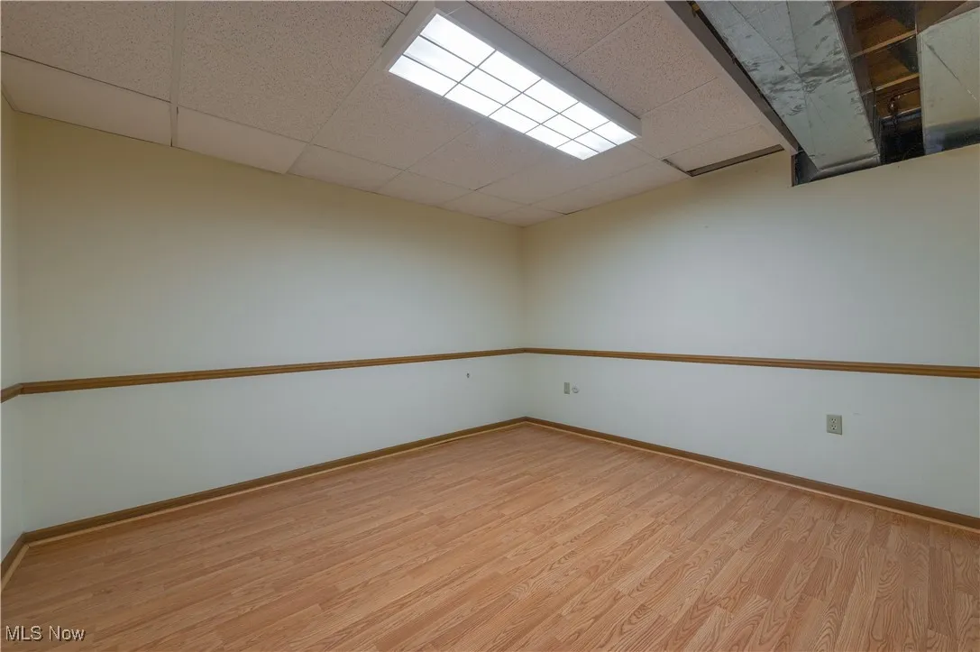Unfurnished room with wood finished floors and a paneled ceiling