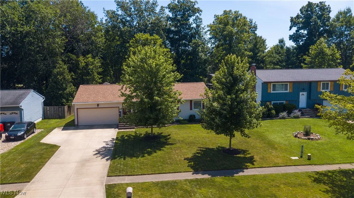 View of front of property with driveway, an attached garage, and a chimney