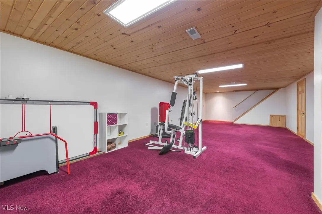 Exercise area featuring carpet floors and wood ceiling