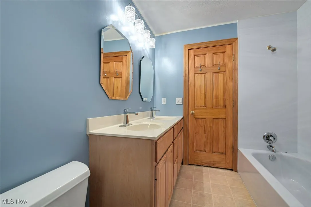 Bathroom with double vanity and tile patterned floors