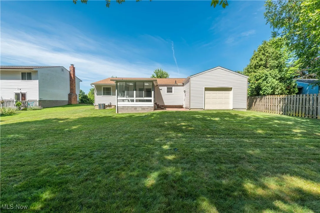 Rear view of house featuring a sunroom and an attached garage