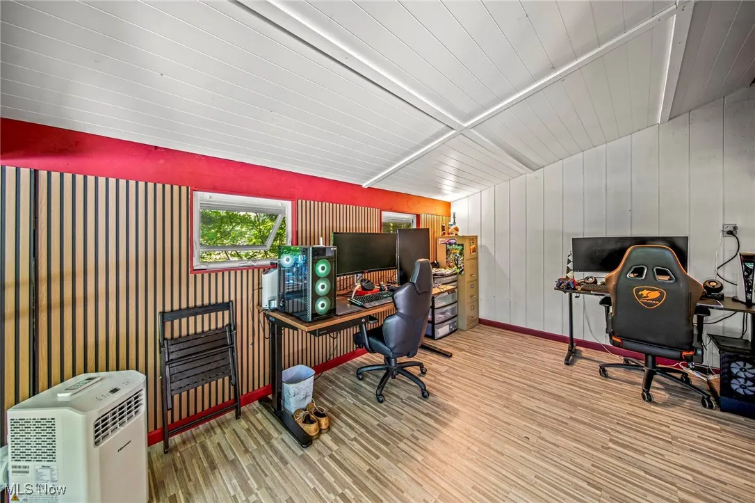 Office area featuring wood finished floors and wooden walls