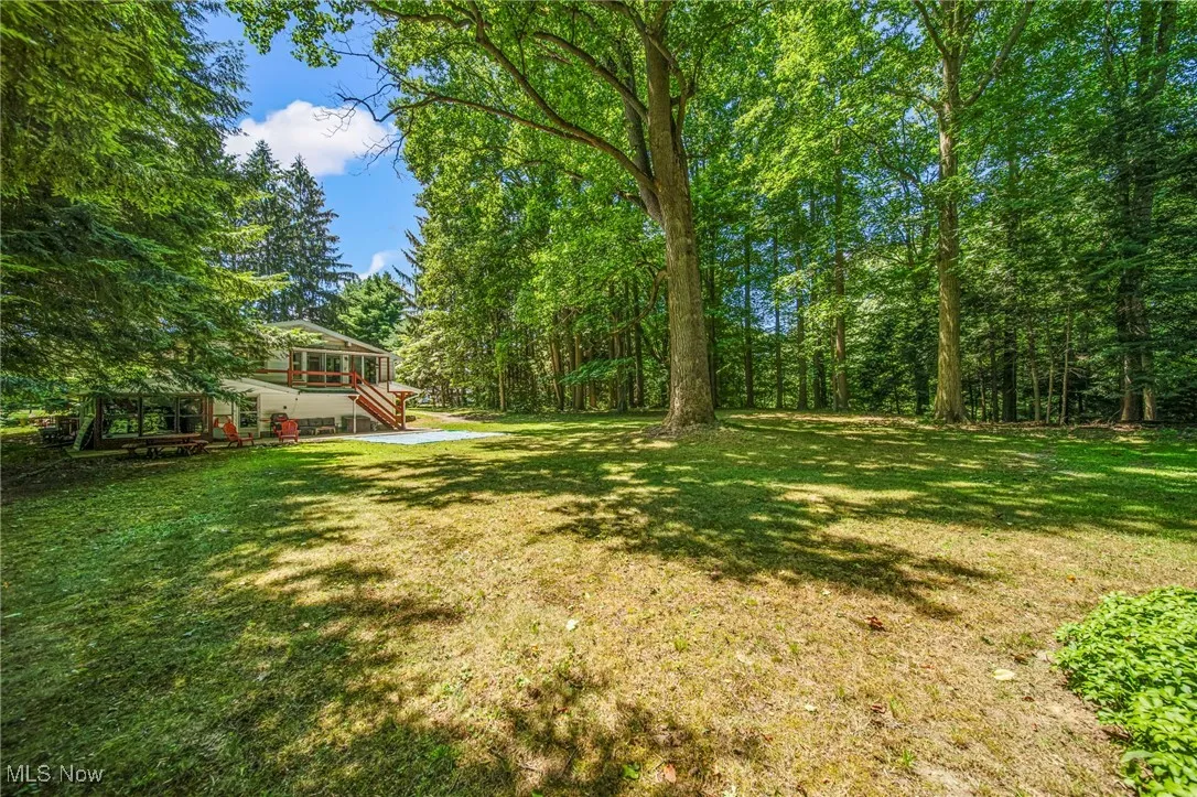 View of grassy yard featuring a wooden deck