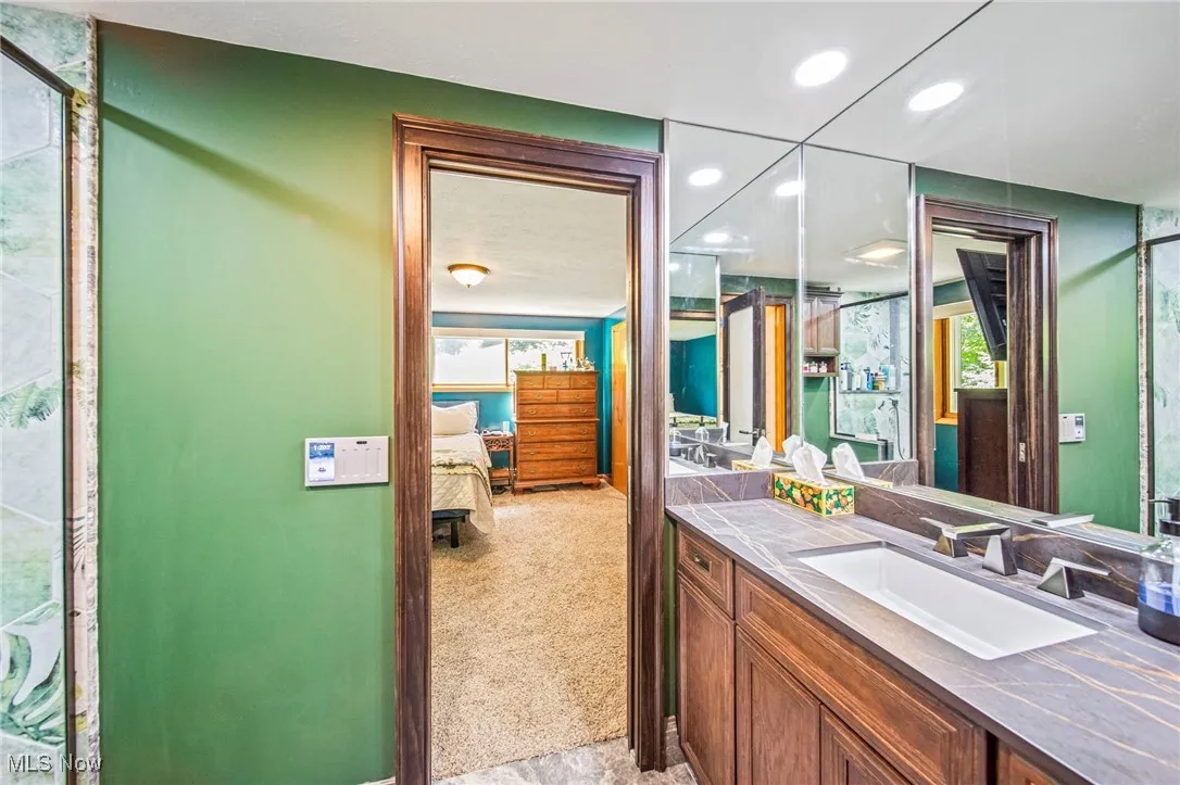 Full bath featuring ensuite bath, vanity, a shower with door, and recessed lighting