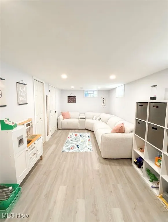 Basement family Room with light wood-type flooring and recessed lighting