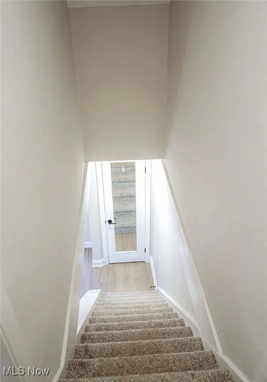 Stairway featuring baseboards and wood finished floors