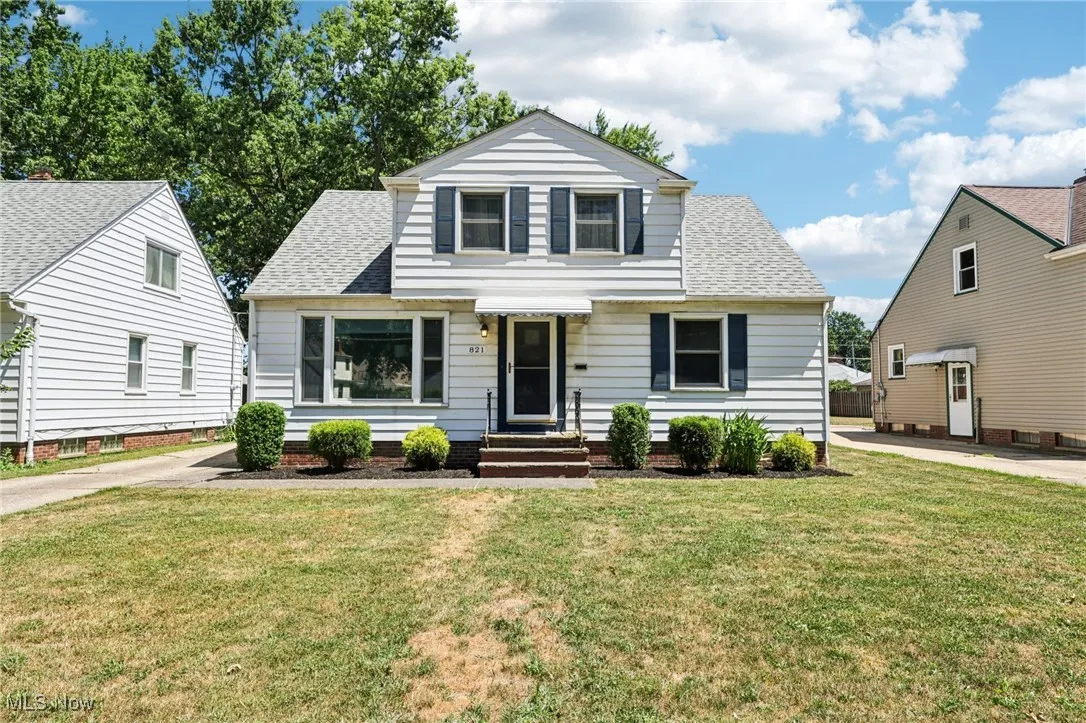 Bungalow-style house with a shingled roof and a front lawn