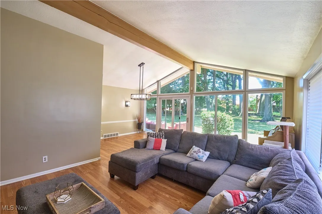 Living area featuring wood finished floors, a chandelier, and a textured ceiling