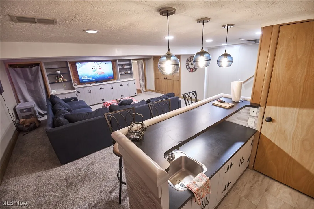 Game room featuring a textured ceiling, recessed lighting, and light colored carpet