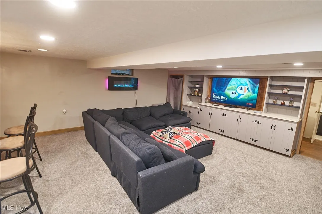 Living area with recessed lighting and light colored carpet