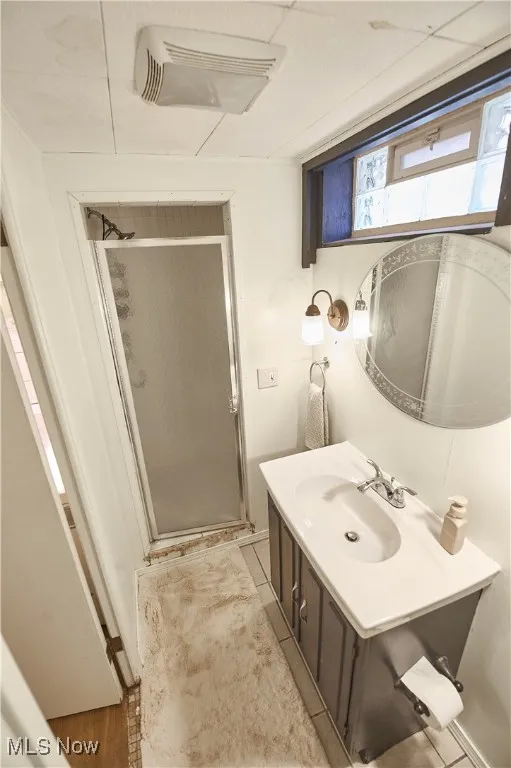 Full bath featuring a stall shower and vanity