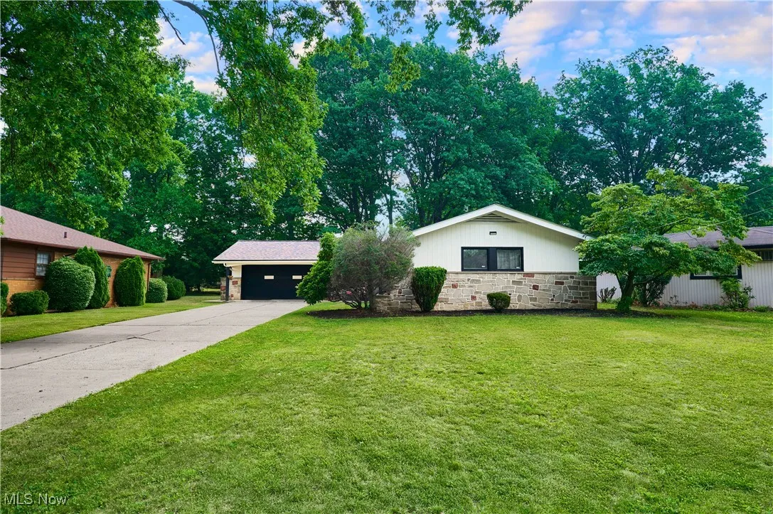 Single story home with a front yard, driveway, and a garage