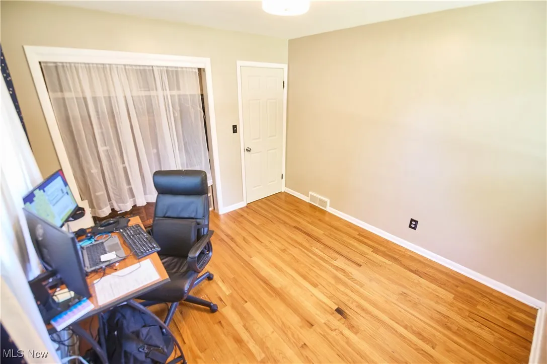 Home office with wood finished floors and baseboards