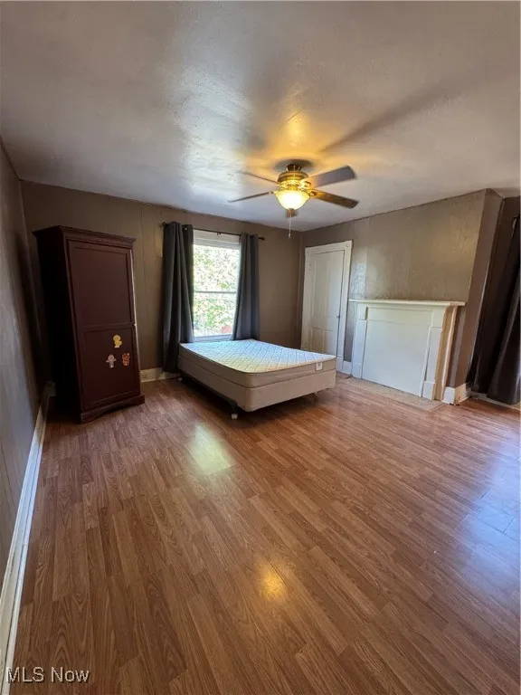 Bedroom featuring wood finished floors, a textured ceiling, and ceiling fan
