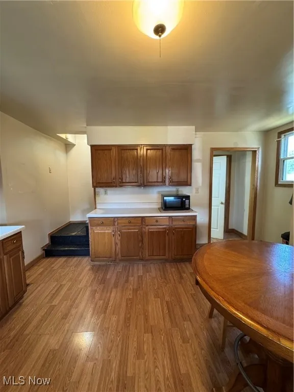 Kitchen featuring light countertops, wood finished floors, and brown cabinetry