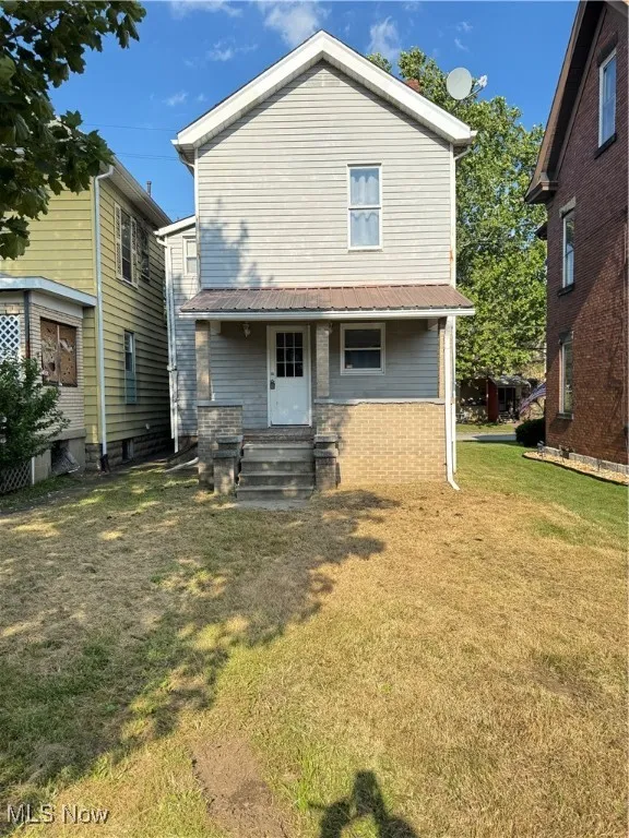 Back of house featuring a yard, a metal roof, and entry steps