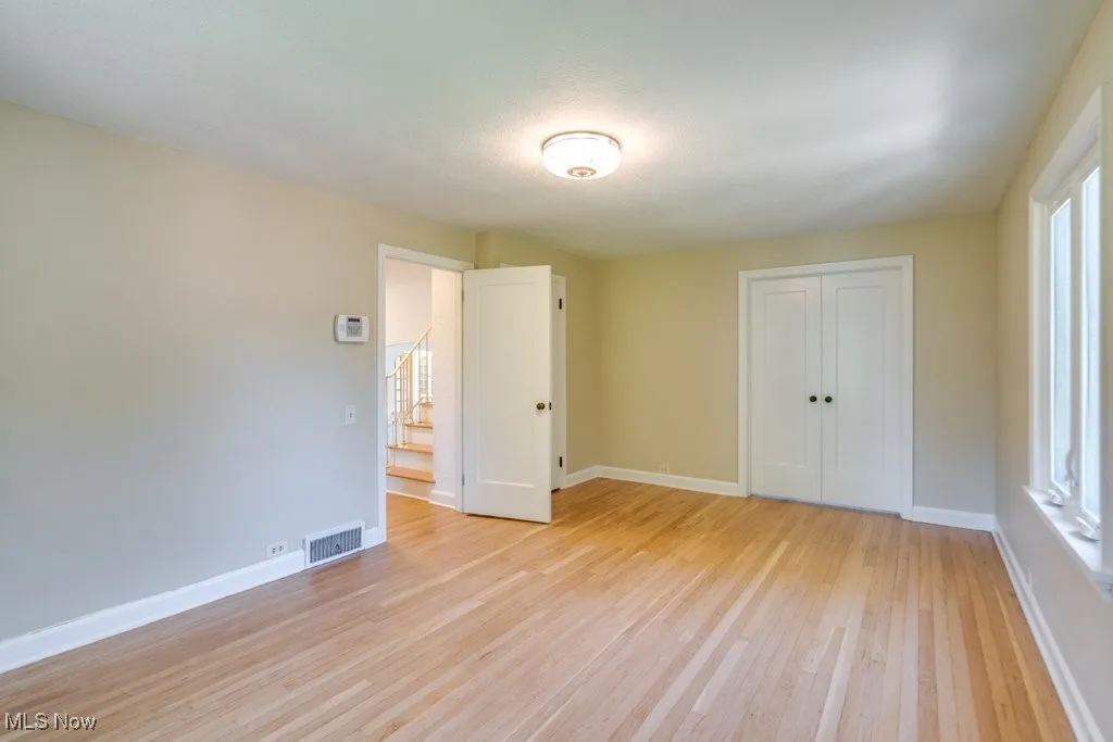Unfurnished bedroom with light wood-style flooring and a closet