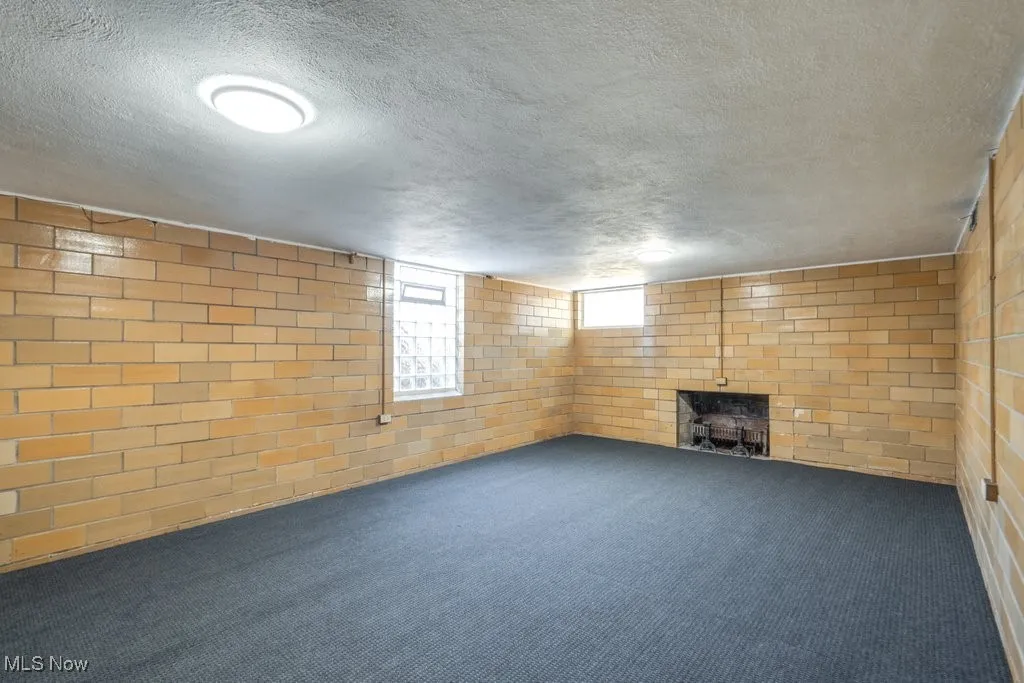 Below grade area featuring carpet, a textured ceiling, and a fireplace