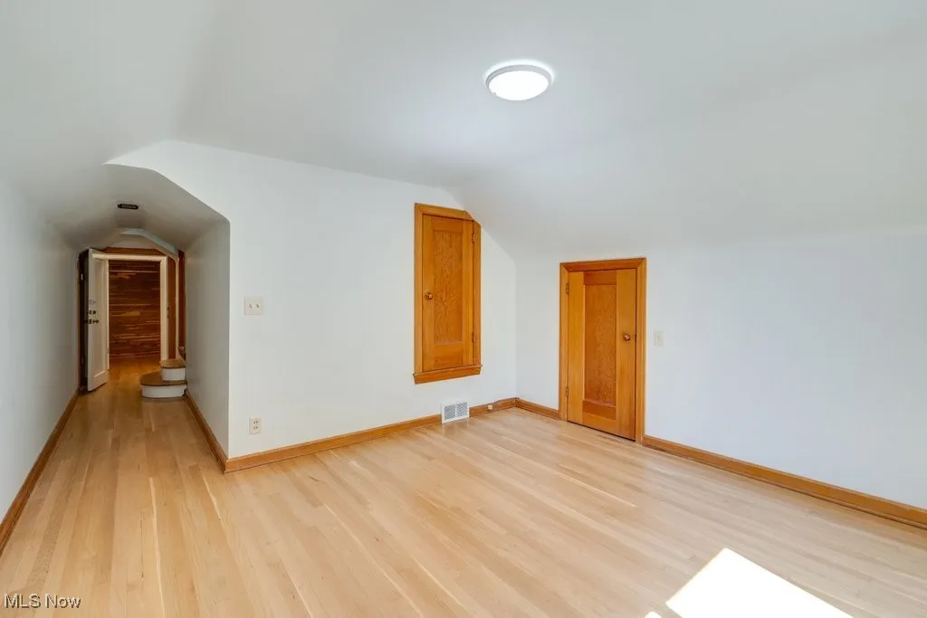 Bonus room featuring light wood-style flooring and lofted ceiling