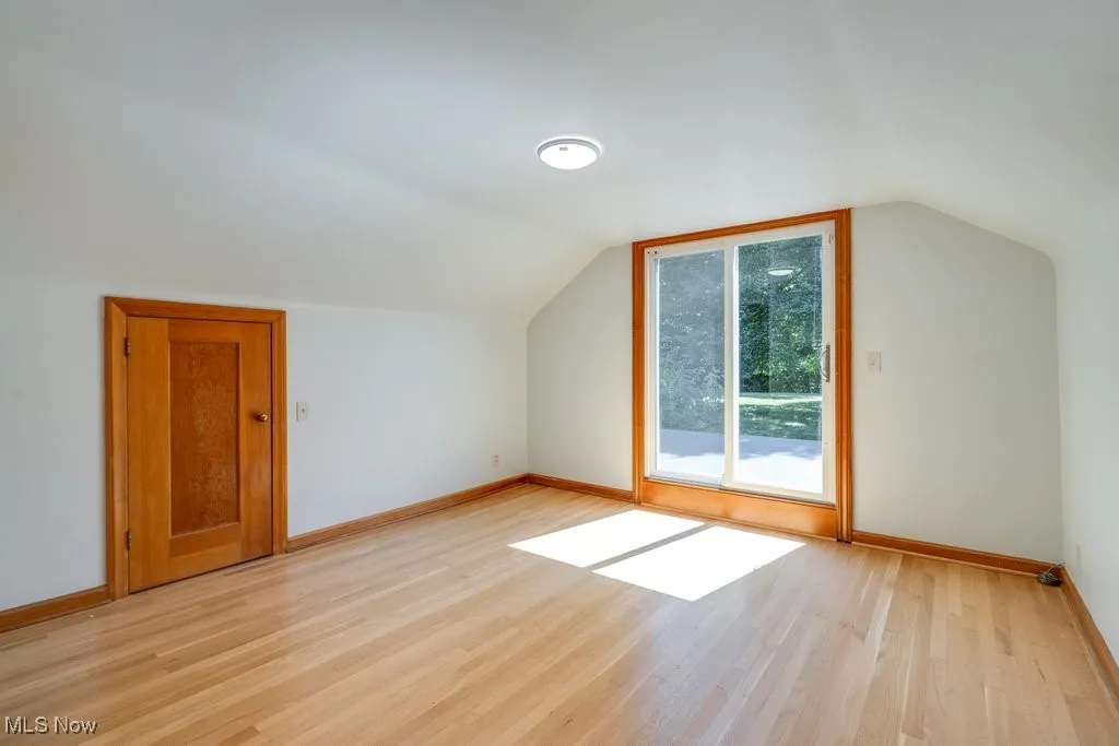 Bonus room featuring light wood-style floors and vaulted ceiling