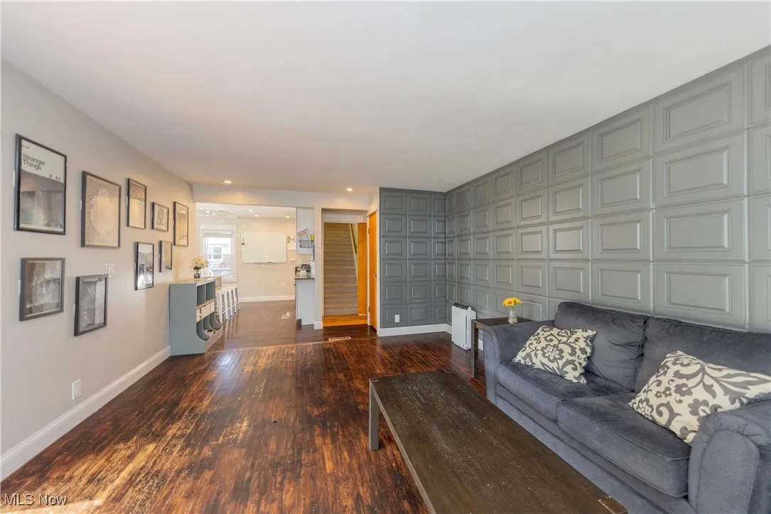 Living area with stairway, wood finished floors, recessed lighting, and an accent wall