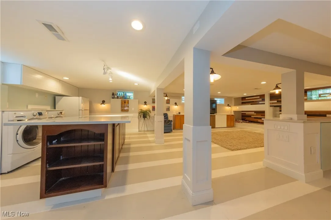 Massive Rec Room in basement featuring laundry area, huge island, and kitchenette...a perfect space to entertain