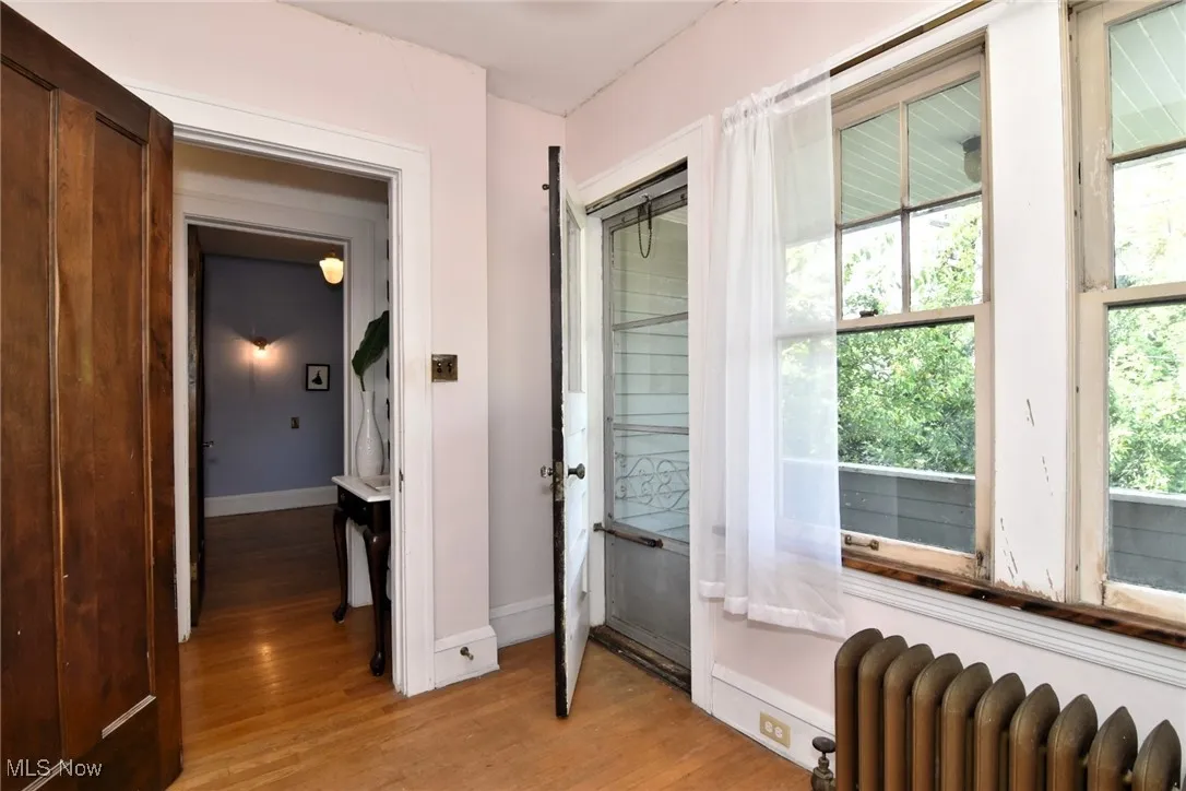 Doorway to outside featuring radiator and light wood-type flooring