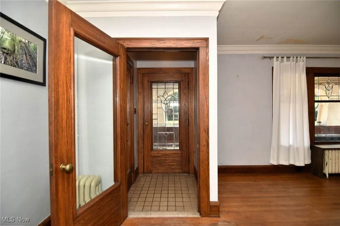 Hallway featuring wood finished floors and radiator