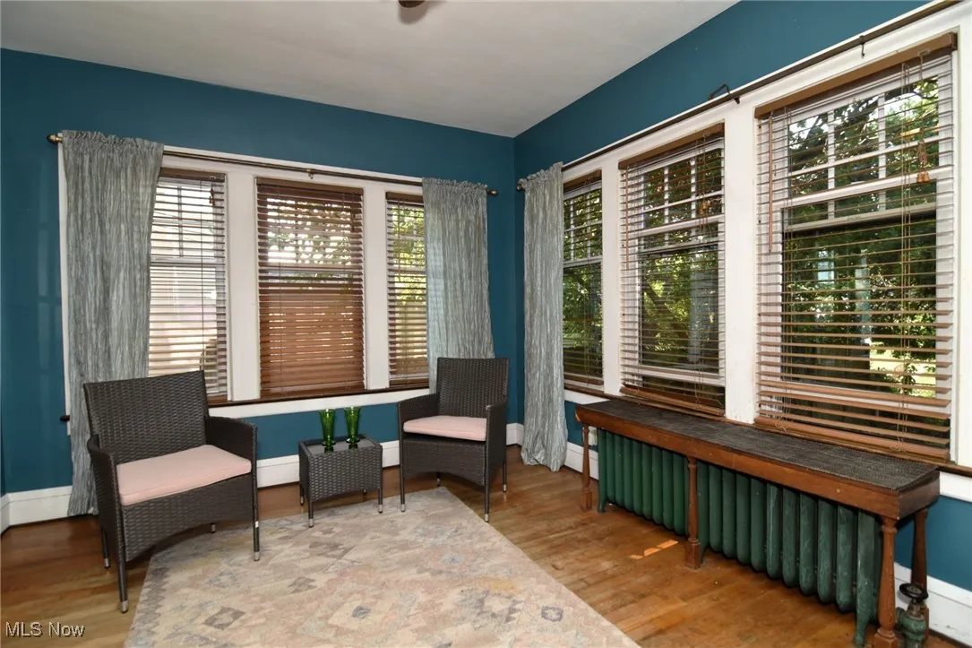 Sitting room featuring wood finished floors and radiator heating unit