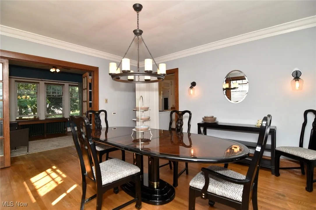 Dining area featuring a chandelier, wood finished floors, ornamental molding, and radiator