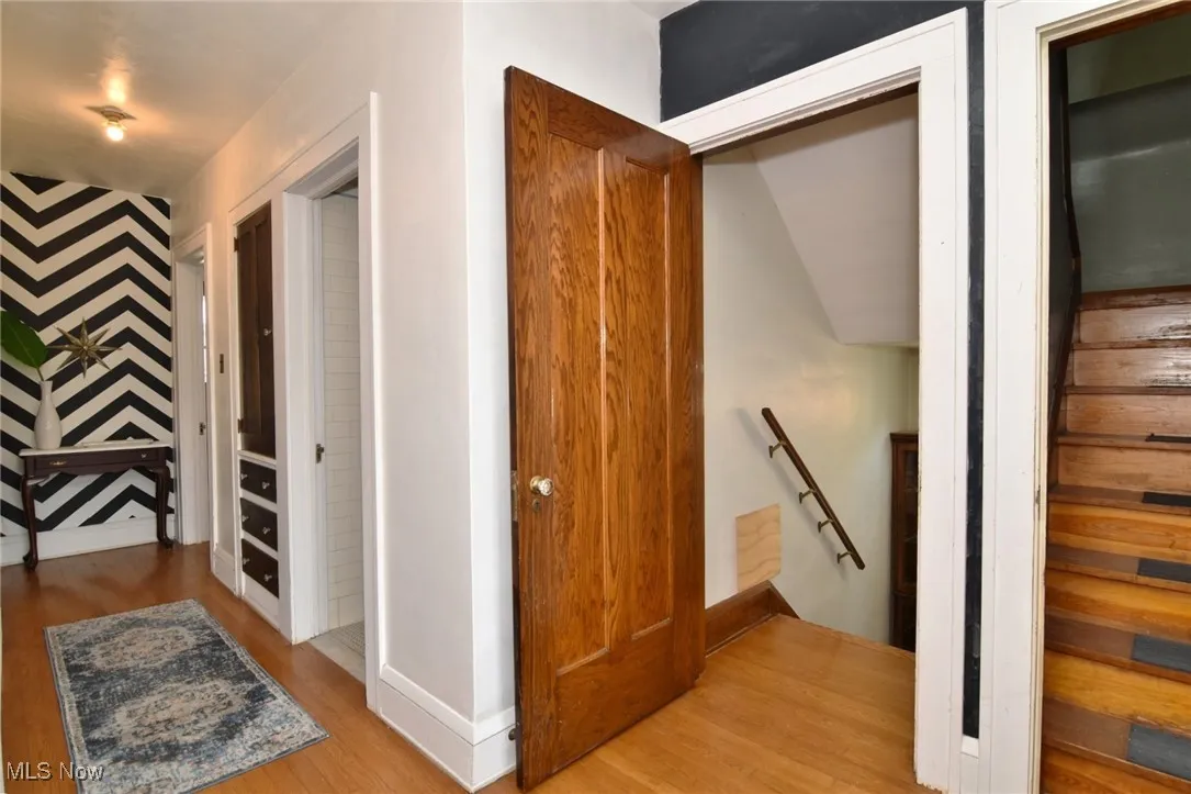 Hallway with an upstairs landing and wood finished floors