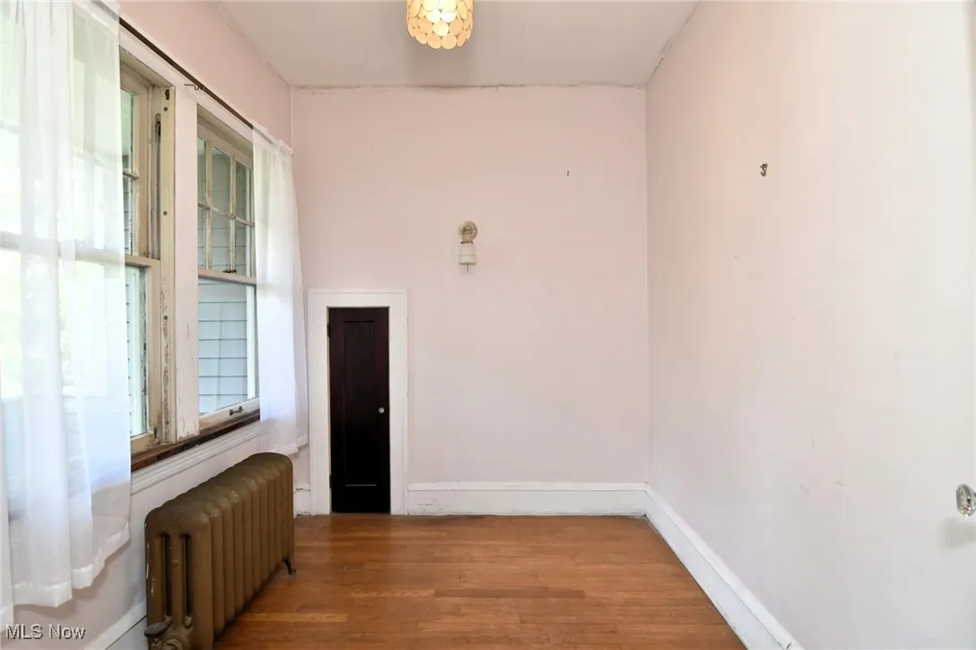 Spare room featuring radiator and wood finished floors
