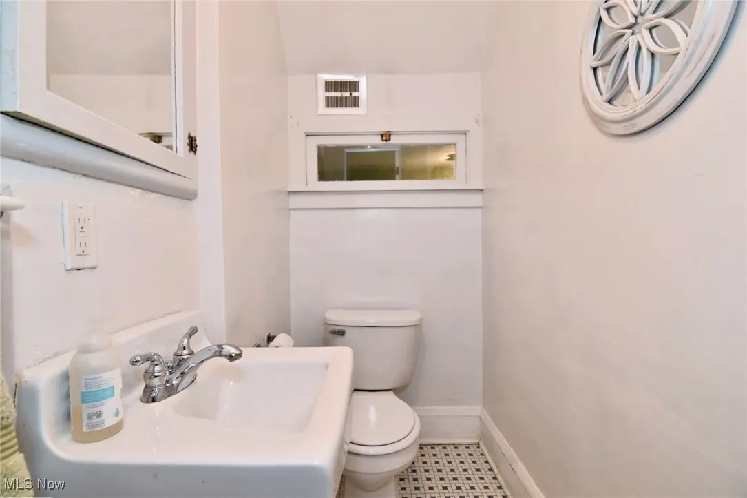 Half bath featuring toilet and baseboards