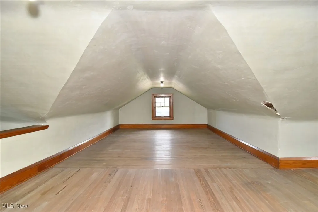 Bonus room with hardwood / wood-style floors and lofted ceiling