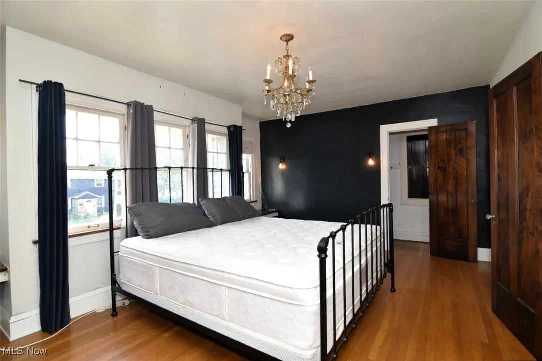 Bedroom featuring wood finished floors and a chandelier