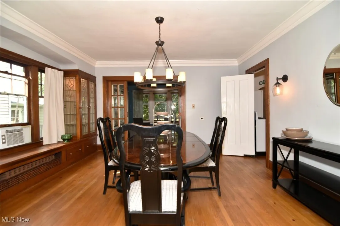 Dining space featuring a chandelier, wood finished floors, and crown molding