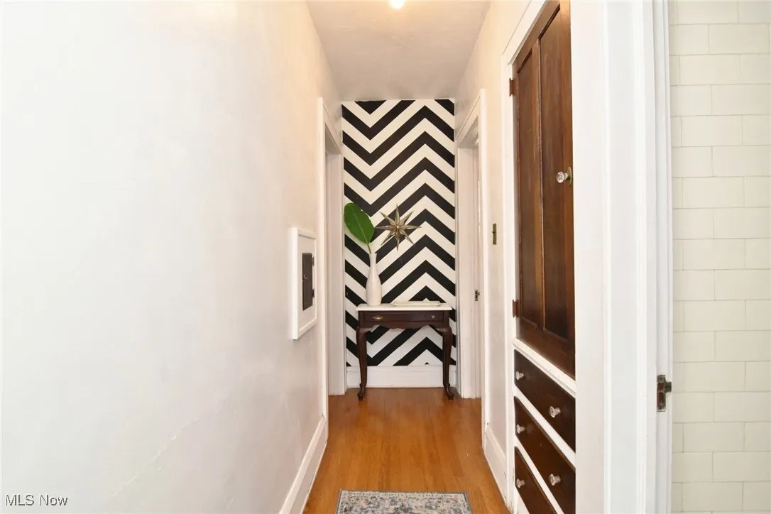 Corridor with wood finished floors and baseboards