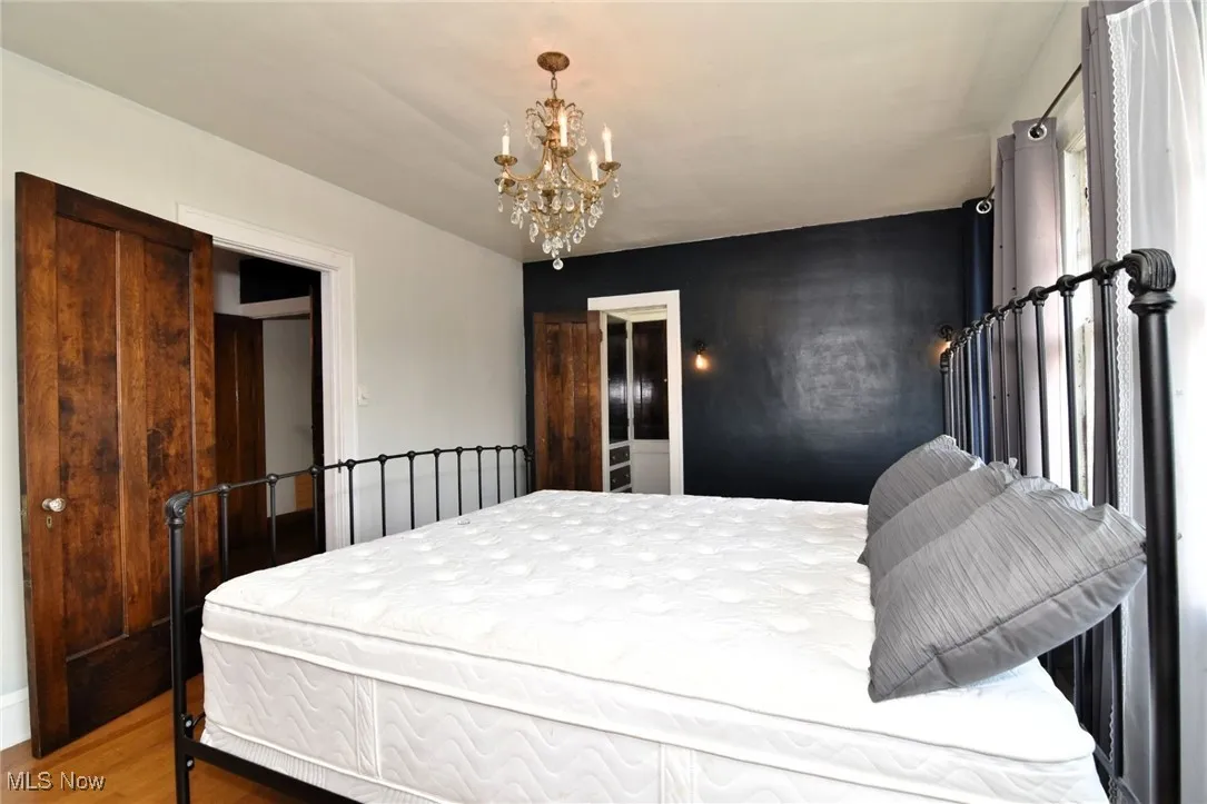 Bedroom with a chandelier and wood finished floors