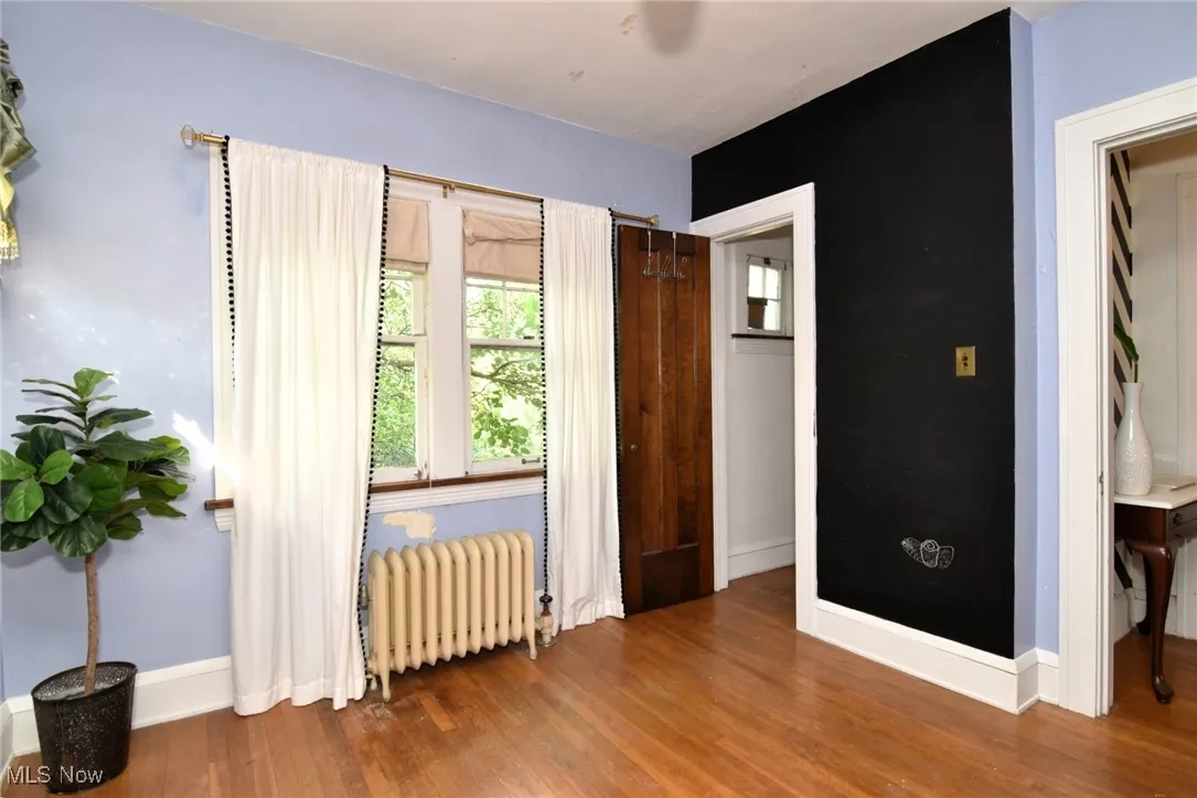 Bedroom with radiator and wood finished floors