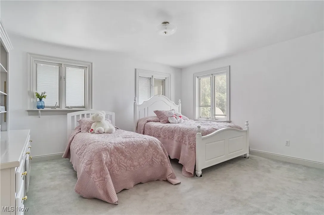 Bedroom with light colored carpet and baseboards