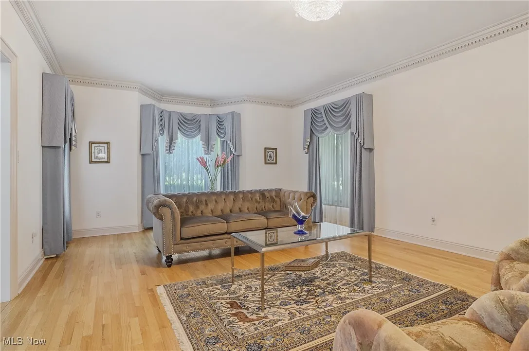 Living area with light wood-style floors and ornamental molding