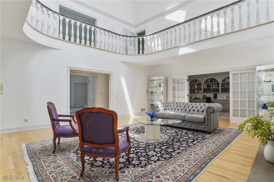 Living room featuring a high ceiling and wood finished floors