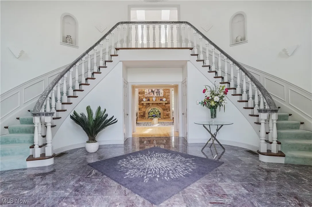 Foyer entrance with stairway, a decorative wall, and a high ceiling
