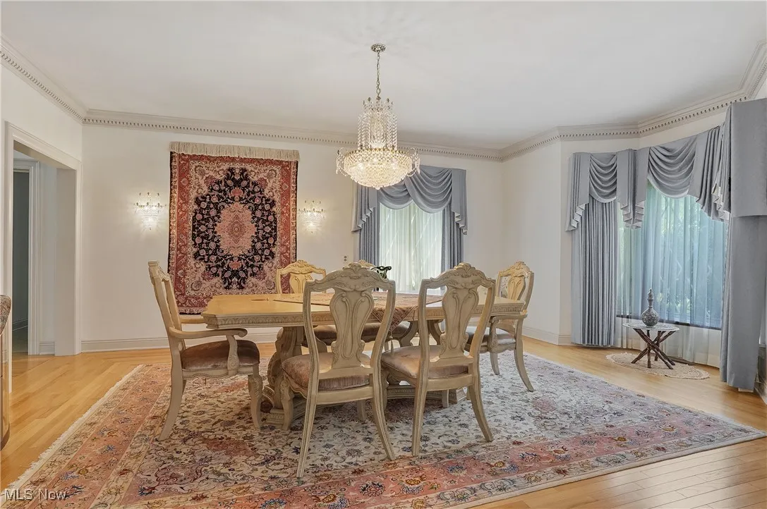 Dining space with a chandelier, light wood-style floors, and ornamental molding