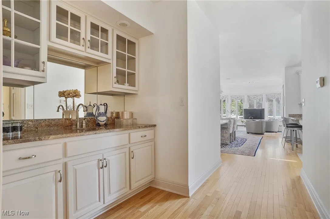 Bar with light wood-type flooring and baseboards