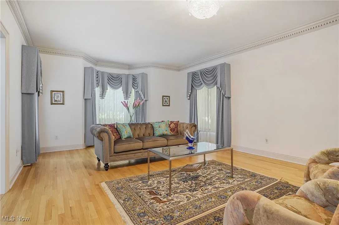 Living room with light wood-style flooring and ornamental molding